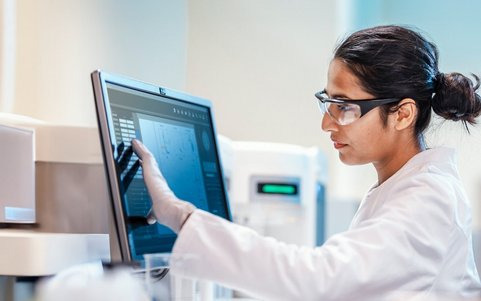 A person in a hazardous materials area looking at a computer screen.