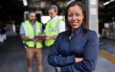 Frau im Vordergrund und 2 Männer mit Warnwesten im Hintergrund