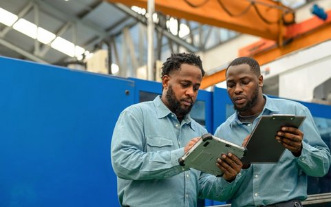 Two occupational safety professionals holding a tablet.