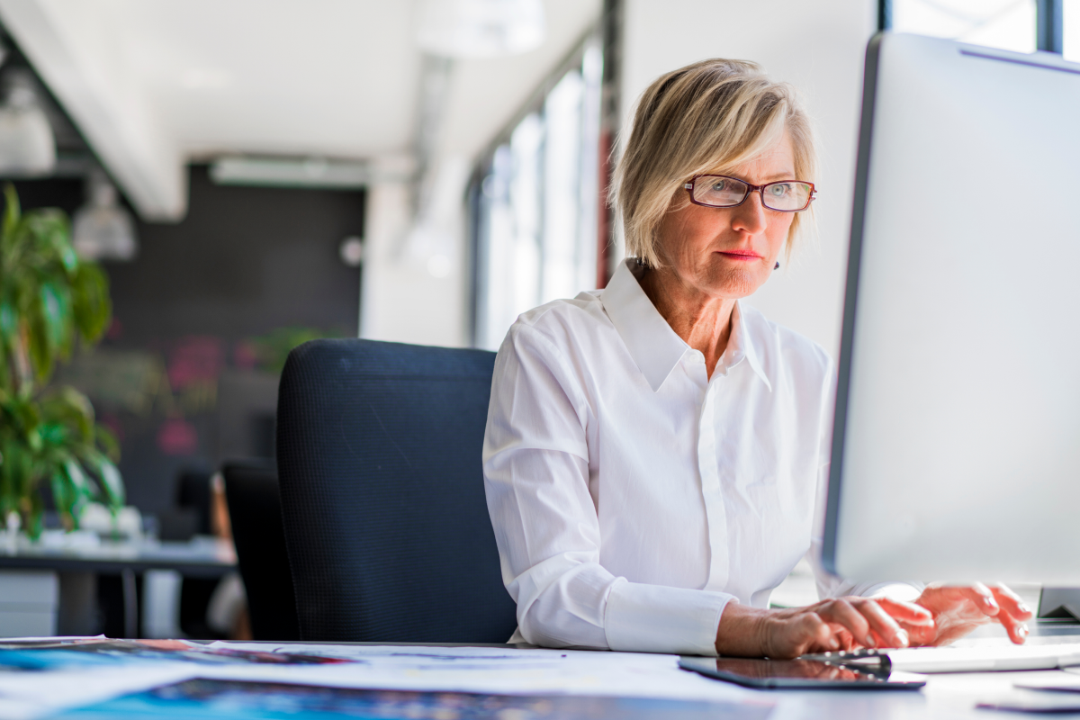 Person, die vor einem Computer sitzt und arbeitet